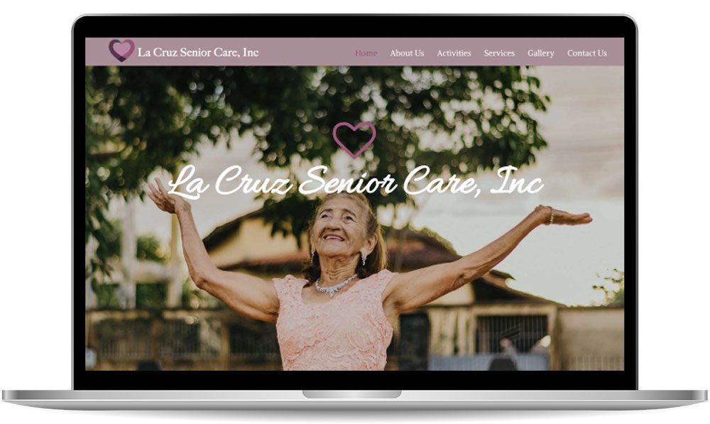 A laptop displays the homepage of La Cruz Senior Care, Inc., featuring an elderly woman smiling with arms raised joyfully against an outdoor backdrop.